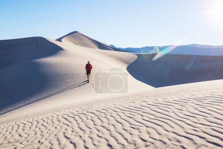 Téléchargez les photos : Randonneur dans le désert de sable. Heure du lever du soleil. - en image libre de droit