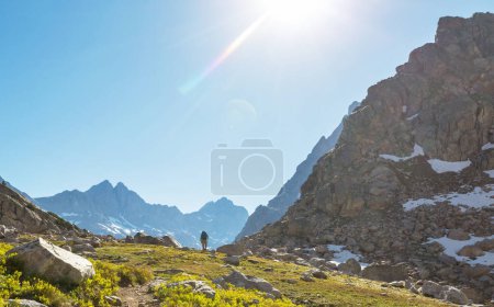 Photo for Hiker in mountains on beautiful rock background - Royalty Free Image