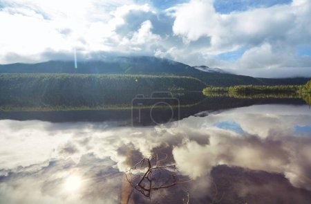Téléchargez les photos : Lac de montagne brumeux tôt le matin serein dans les montagnes. - en image libre de droit