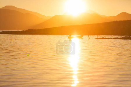 Photo for Fisnermen in boats on the lake at sunrise - Royalty Free Image