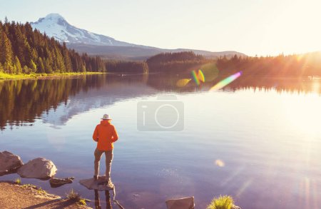 Téléchargez les photos : Un homme se repose à l'aise près du lac calme. Vacances de détente - en image libre de droit