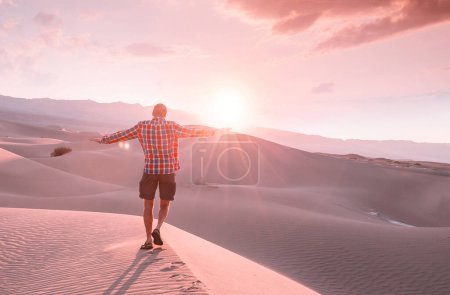 Photo for Hiker in sand desert. Sunrise time. - Royalty Free Image