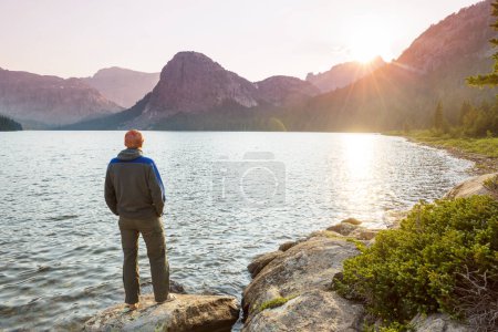Photo for A man is resting at ease by the calm lake. Relaxation vacation - Royalty Free Image