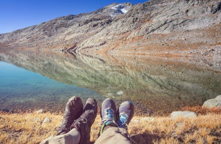 Téléchargez les photos : Couple relaxant près du magnifique lac des montagnes - en image libre de droit
