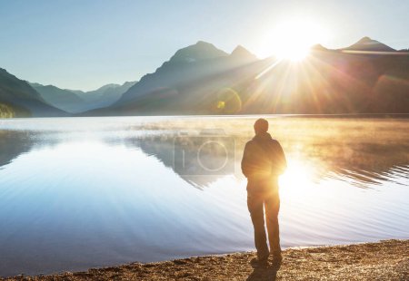 Téléchargez les photos : Un homme se repose à l'aise près du lac calme. Vacances de détente - en image libre de droit