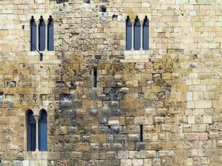 Foto de Rustic medieval sandstone wall with ancient windows. - Imagen libre de derechos