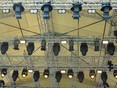 Spotlight devices in a row on  rigging steel trusses, installation of professional stage concert equipment.