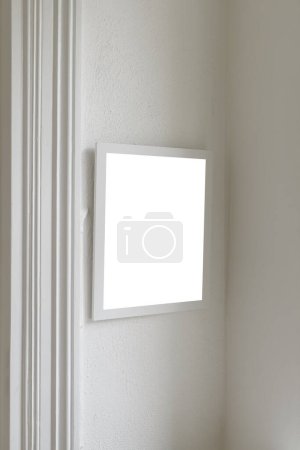 Photo for White wooden picture frame with mockup space for photography hanging on living room wall, selective focus - Royalty Free Image