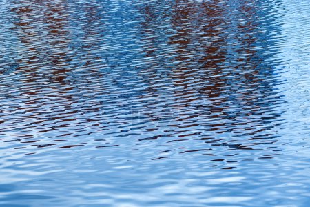 Téléchargez les photos : Surface de l'eau de rivière bleue avec ondulations et réflexion de la lumière. Texture d'eau douce propre de la rivière Nissan dans la ville de Halmstad en Suède. Concentration sélective. - en image libre de droit