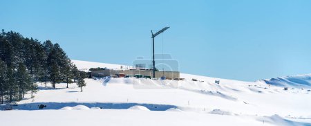 Téléchargez les photos : Construction d'un chantier et d'une grue sur une colline enneigée en hiver à la montagne Zlatibor en Serbie - en image libre de droit