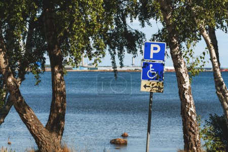 Photo for Reserved disabled parking space sign at Kattegat sea shoreline in Halmstad, Sweden. Selective focus. - Royalty Free Image