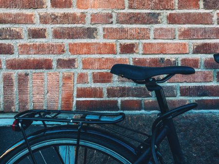 Téléchargez les photos : Siège de vélo appuyé sur un mur de briques à Halmstad, Suède. Concentration sélective. - en image libre de droit