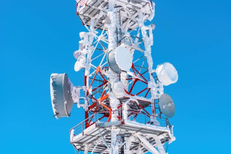 Téléchargez les photos : Antennes de tour de communication recouvertes de neige avec ciel bleu comme espace de copie - en image libre de droit