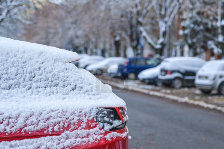 Téléchargez les photos : Voitures sous la première neige de l'hiver sur le parking dans le quartier résidentiel, accent sélectif - en image libre de droit