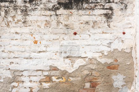 Téléchargez les photos : Vieille texture de façade murale en brique avec de la peinture blanche décollant de la surface comme fond - en image libre de droit