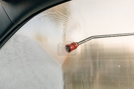 Foto de Pulverizador de chorro de pistola de agua de alta presión en auto-servicio de lavado de autos, enfoque selectivo - Imagen libre de derechos