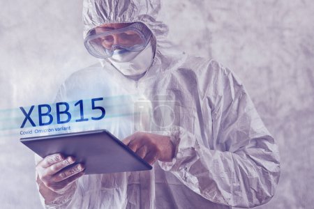Photo for Health care professional medical worker in protective clothing using digital tablet to gather information on new covid strain omicron variant dubbed XBB15 - Royalty Free Image