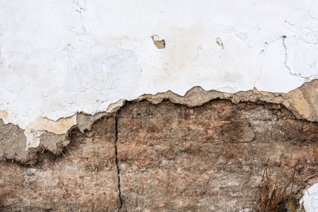 Alte beschädigte Lehmziegelmauer eines alten verfallenen Hauses als Hintergrund