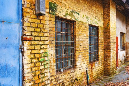 Foto de Viejas ventanas de rejilla con cristales rotos en la pared exterior de un antiguo edificio de almacén de fábrica abandonado - Imagen libre de derechos