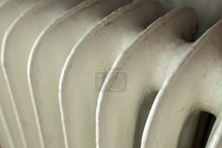 Téléchargez les photos : Old cast iron household central heating radiator in living room, closeup with selective focus - en image libre de droit