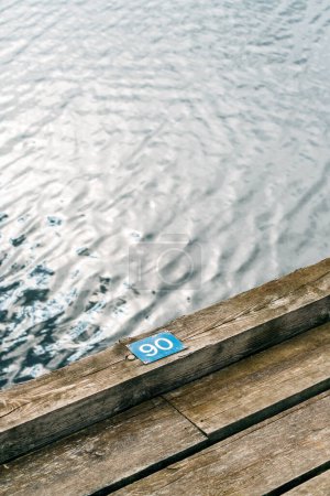 Photo for Nissan river wooden quay numeration plates in Halmstad, Sweden. Number 90 with selective focus. - Royalty Free Image
