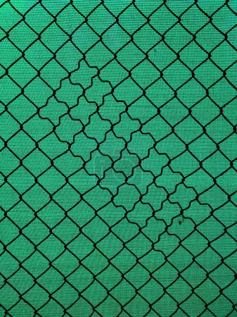Photo for Chain-link fencing with the diamond pattern and green fiber screening as background - Royalty Free Image