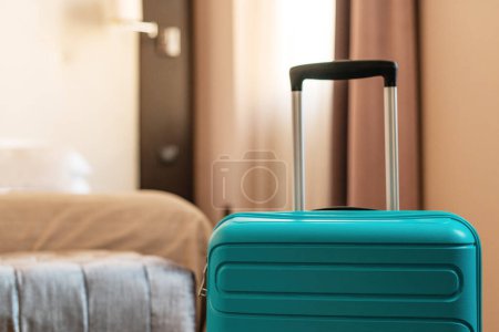 Foto de Blue travel suitcase in hotel apartment bedroom - Imagen libre de derechos