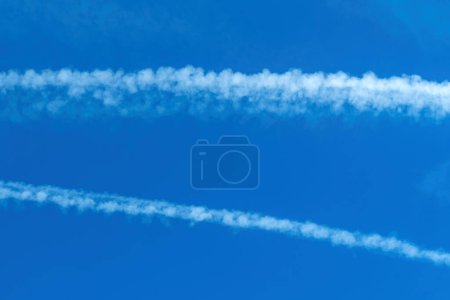 Foto de Airplane contrail across the blue sky, copy space included - Imagen libre de derechos