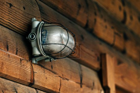 Photo for Outdoor wall light on lodging cottage wooden door, selective focus - Royalty Free Image