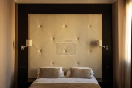 Téléchargez les photos : Hotel room bedroom furniture - a bed with headboard, pillows and bedside lamps - en image libre de droit