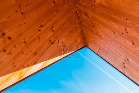 Téléchargez les photos : Vue du ciel bleu d'hiver à travers le plafond en bois de pin, mise au point sélective - en image libre de droit