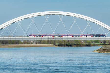 Téléchargez les photos : Novi Sad, Serbie - 24 mars 2023 : Train à grande vitesse Soko sur le pont Zezelj sur le pont du Danube. Ce train circule entre Belgrade et Novi Sad et peut atteindre une vitesse de 200 km / h - en image libre de droit