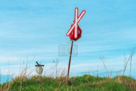 Téléchargez les photos : Croix de St Andrew et panneau d'arrêt au passage à niveau dans la campagne - en image libre de droit