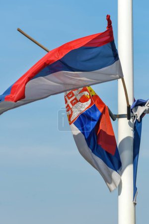 Photo for Torn and weathered flag of Serbia on a post waving in wind, selective focus - Royalty Free Image