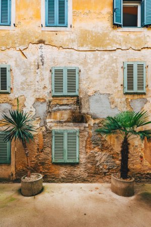 Photo for Old town of Lovran in Croatia, distinctive Istrian architecture with worn facades and wooden window shutters, selective focus - Royalty Free Image