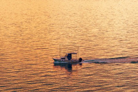 Téléchargez les photos : Dériveur bateau de pêche en mer au coucher du soleil, mise au point sélective - en image libre de droit
