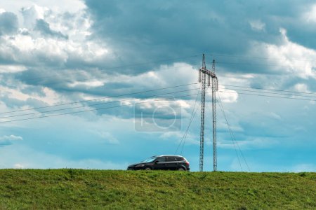 Photo for Speeding car on country road with electricity pylon in background, selective focus - Royalty Free Image