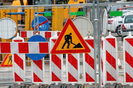 Photo for Men at work road sign at construction site during city street road maintenance, selective focus - Royalty Free Image