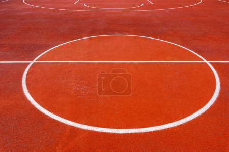 Téléchargez les photos : Fond abstrait minimaliste d'un terrain de basket-ball extérieur en tartan orange avec des lignes blanches. Concentration sélective. - en image libre de droit