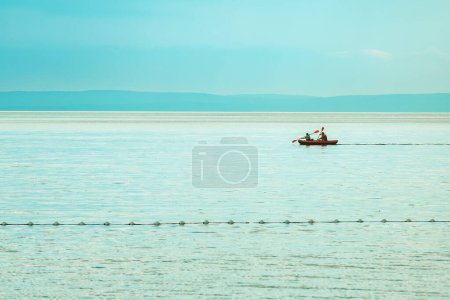 Téléchargez les photos : Deux personnes ramant un canot pneumatique au golfe du Kvarner de la mer Adriatique le matin d'été. Concept de style de vie de vacances actif. Concentration sélective. - en image libre de droit