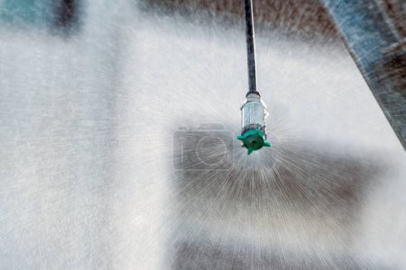 Photo for Closeup of agricultural sprinkler head spraying water drops at field, selective focus - Royalty Free Image