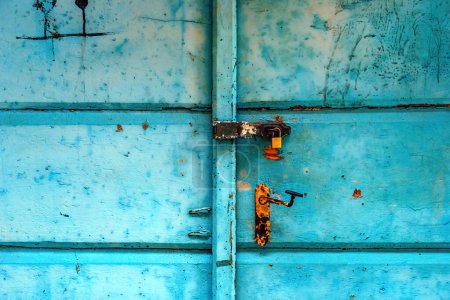 Photo for Old worn wooden door with rusty handle and padlock as background - Royalty Free Image