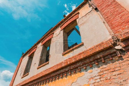 Téléchargez les photos : Ancien bâtiment en ruine avec fenêtres cassées, vue à angle bas - en image libre de droit