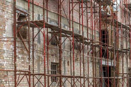 Foto de Estructura de andamios en obra, renovación de un antiguo edificio industrial, enfoque selectivo - Imagen libre de derechos