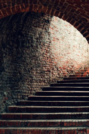 Téléchargez les photos : Passage en brique vintage avec escalier menant à la sortie de lumière, mise au point sélective - en image libre de droit