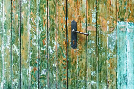 Téléchargez les photos : Porte et poignée en bois rustique avec peinture décollant de la surface comme fond grunge - en image libre de droit