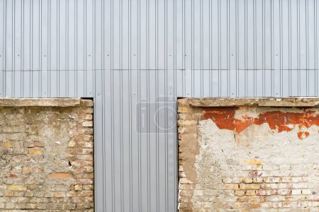 Téléchargez les photos : Ancien bâtiment industriel en ruine fermé avec des plaques de tôle ondulée comme fond - en image libre de droit