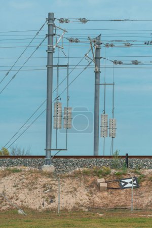 Photo for Electric train railway line tension pole with wires and concrete weights, selective focus - Royalty Free Image
