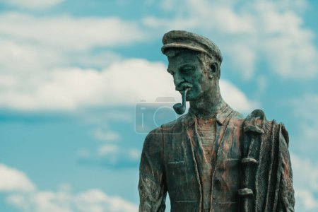 Foto de Crikvenica, Croacia - 20 de julio de 2023: La estatua del pescador de bronce en el puerto de Crikvenica, obra de Zvonko Car, famoso artista nacido en esta ciudad croata - Imagen libre de derechos