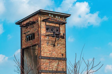 Foto de Antigua torre transformadora de cabina de electricidad abandonada desgastada hecha de ladrillos, contra el cielo azul - Imagen libre de derechos